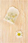 Bag of chamomile tea over wooden background - concept