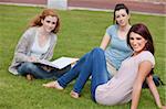 Young women sitting on the lawn looking at the camera