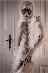 pretty blonde girl wearing a feather boa and panties posing in a doorway