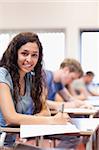 Portrait of a serious student writing in a classroom