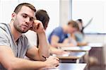 Young man posing in a classroom