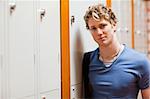 Portrait of a student leaning on a locker in a corridor