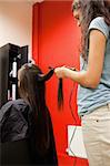 Portrait of a woman straightening hair with a hair straightener