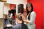 Blond-haired young man having a haircut with scissors