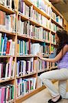 Portrait of a female student choosing a book in a library