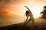 asian girl posing yoga on beautiful beach during sunset