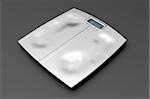 Metal weight scale with footprints on gray background