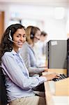 Portrait of a smiling assistant working with a computer in a call center