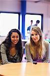 Portrait of friends posing with a mobile phone in a student home