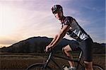 sports activity: young adult cyclist riding mountain bike in the countryside. Horizontal shape, side view, copy space