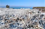 a seasonal snow covered view of atlantic ocean and ballybunion castle beach and cliffs on a frosty snow covered winters day