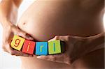 Pregnant Woman Holding Blocks Spelling "Girl"