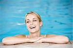 Young Woman Resting On Edge Of Swimming Pool