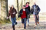 Family Running Through Autumn Countryside