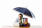 Businessman holding umbrella in the office