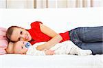 Smiling mother and baby laying on couch