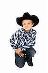 Young cowboy wearing a hat against white