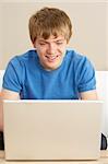 Young Boy Using Laptop At Home