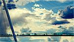 Modern bridge against the cloudy sky and people silhouettes