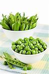 Pods green sweet organic peas in two bowl