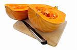 Sliced in half pumpkin lying on a board with a knife. Isolated over white. Clipping path.