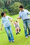 Happy Asian family walking in the park