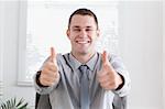 Happy businessman giving thumbs up