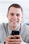 Close up of modern cellphone being held by smiling businessman