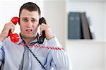 Close up of stressed businessman unable to cope with the telephone