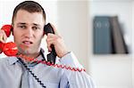 Stressed businessman troubled by the telephone