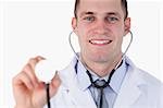 Close up of smiling doctor using stethoscope on white background