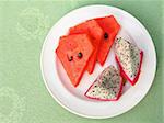 Ripe watermelon and dragon fruit slices on plate on restaurant table