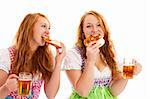 two bavarian women eating pretzels and holding beer on white background