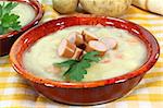 a red bowl of potato soup with parsley