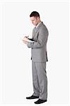 Portrait of a serious businessman taking notes against a white background