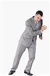 Portrait of a handsome businessman pushing a wall against a white background