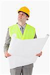 Portrait of a builder looking around while holding a plan against a white background