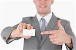 Businessman pointing at a blank business card against a white background