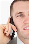 Close up of a handsome businessman making a phone call against a white background