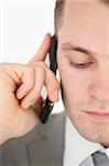 Close up of a sad businessman making a phone call against a white background