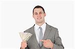 Businessman pointing at a wad of cash against a white background