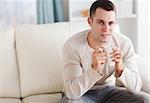 Good looking man having a coffee in his living room