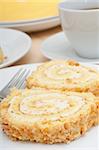Swiss Sponge Roll With Cream and Walnuts and Coffee on Table