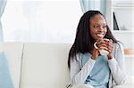 Smiling woman with a cup on couch