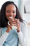 Close up of smiling woman sitting on couch with a cup