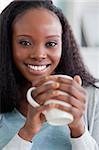 Close up of smiling woman having coffee on couch