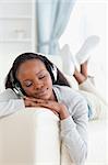 Young woman enjoying music on her couch