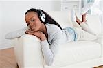 Young woman relaxing with music on her sofa