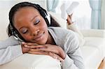 Close up of young woman relaxing with music on her sofa