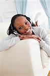 Smiling woman enjoying music on sofa